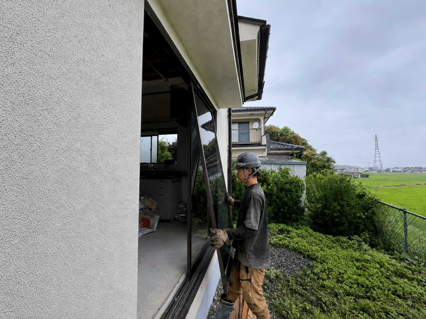 重機作業の前に建具を手作業で撤去している住宅解体現場